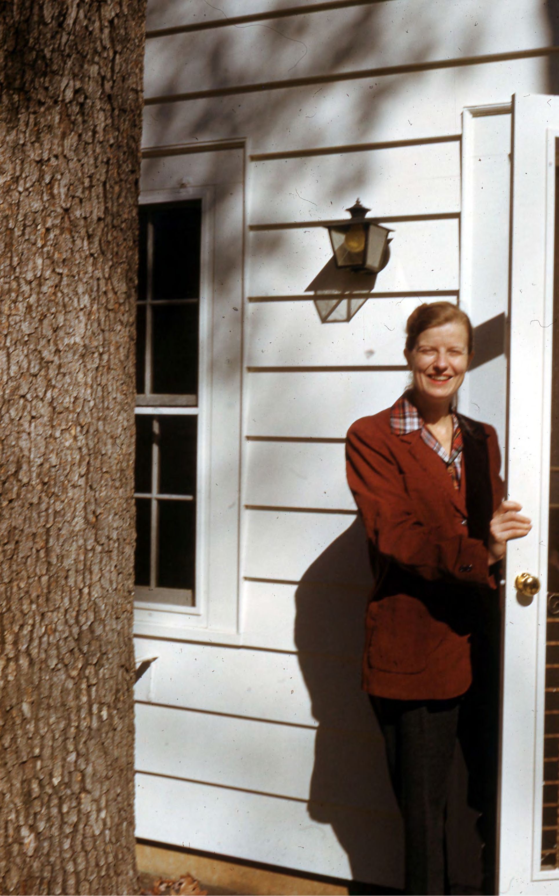 Photograph of woman in front of house [JPG]